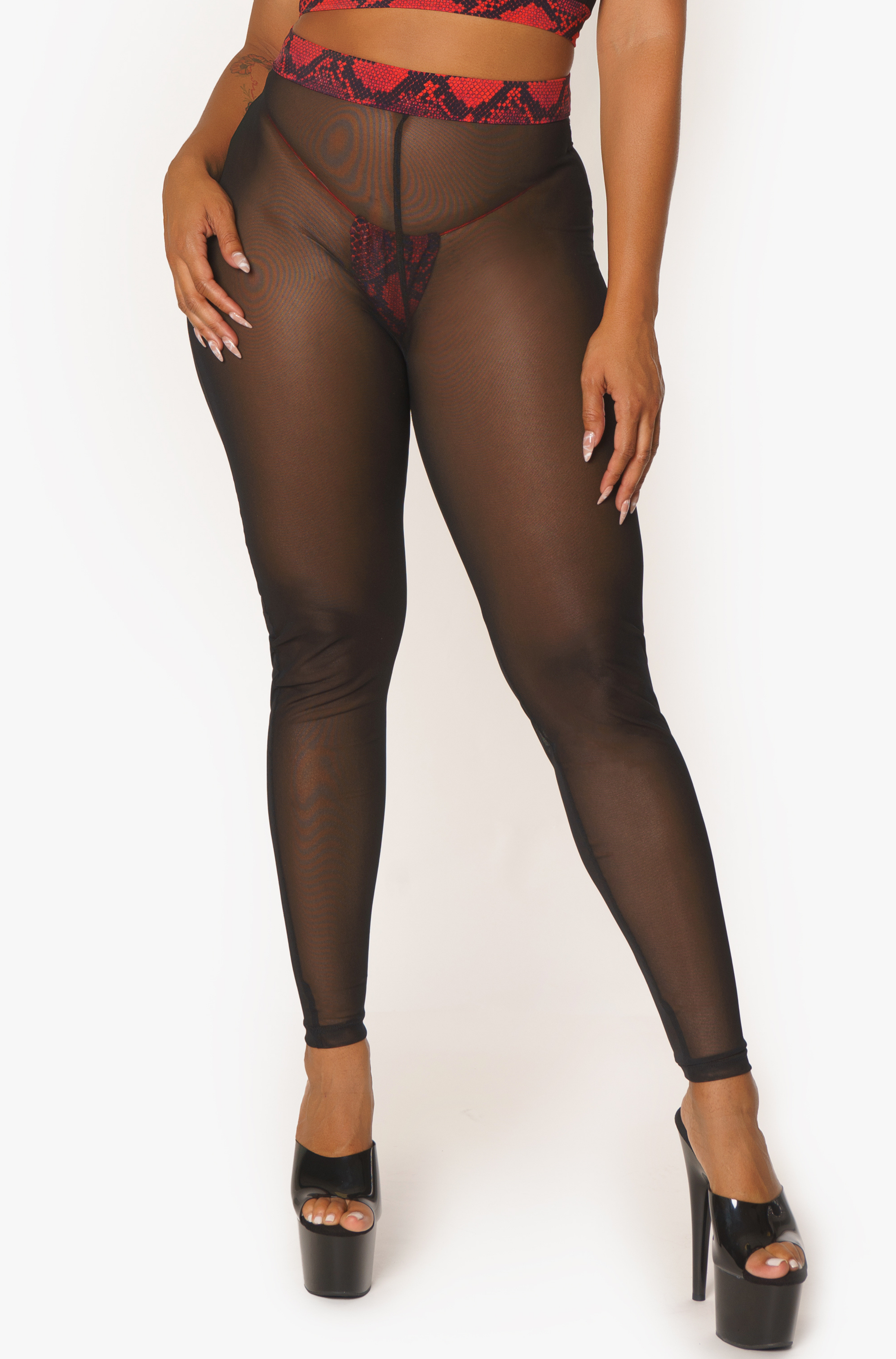 Pantalones de malla negra con detalles de serpiente roja